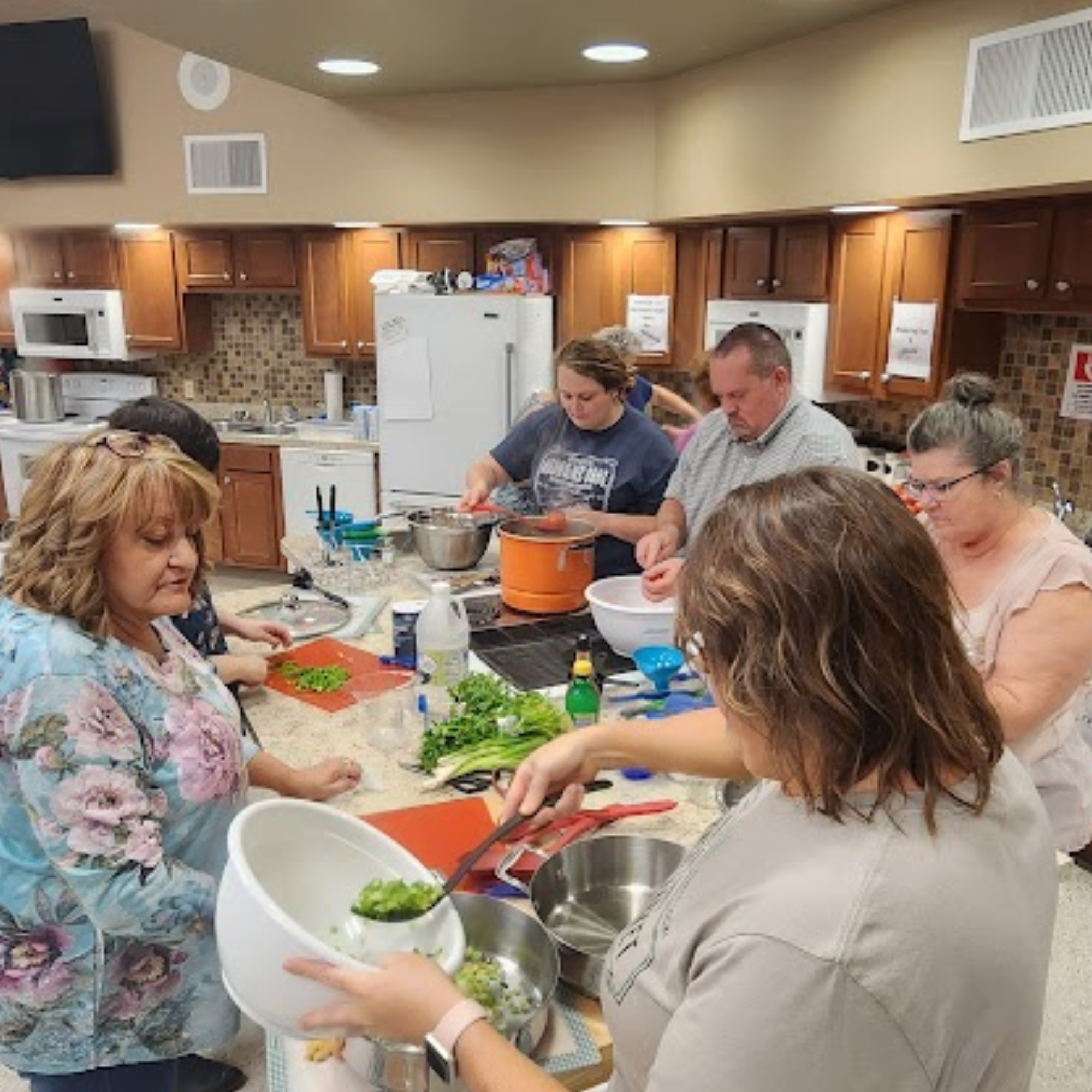 Photo of a group of people preparing ingredients for a canning class.